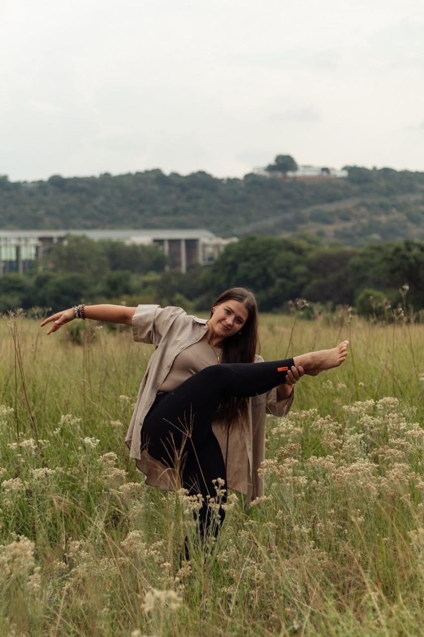 Chané Venter, director of Diamond Dance Company, mid-pose in a field