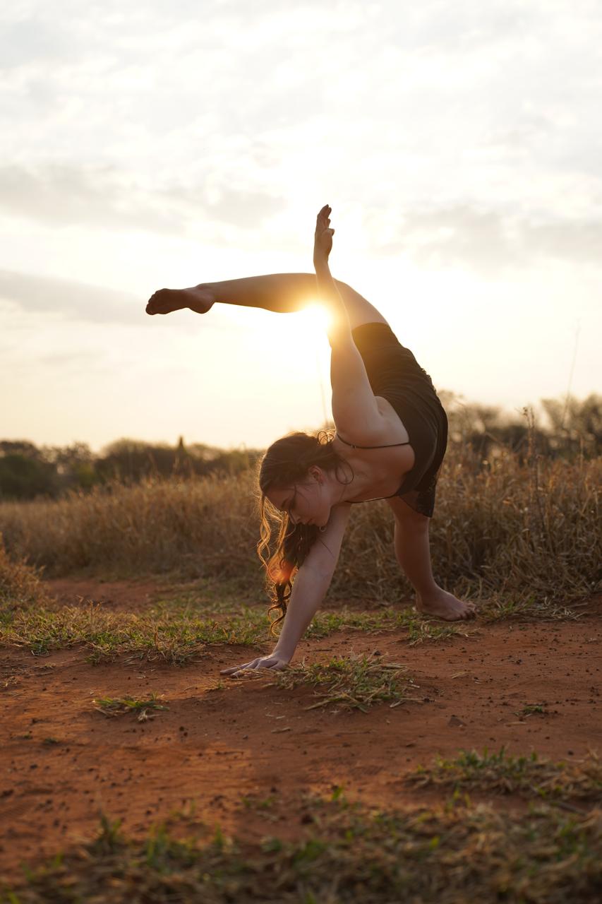 A dancer in a sunset balance, backlit by the sun